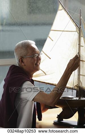 mature man working on model sail boat and smiling View Large Photo Image Stock Image - mature man working on model sail boat and smiling. Fotosearch