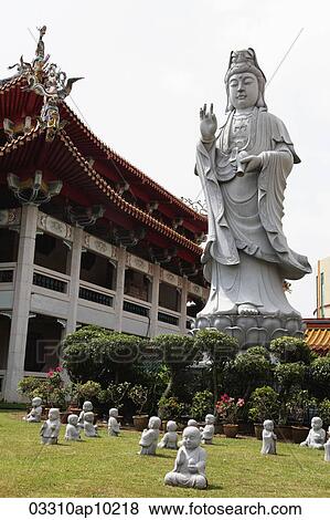 Stock Photo - Statues of Buddha in front of temple. Fotosearch