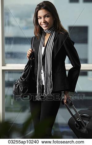young woman holding bag and pulling suitcase View Large Photo Image Stock Image - young woman holding bag and pulling suitcase. Fotosearch