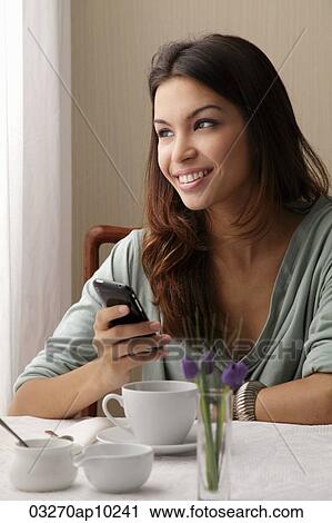 young woman texting on phone a cafe View Large Photo Image Stock Image - young woman texting on phone a cafe. Fotosearch