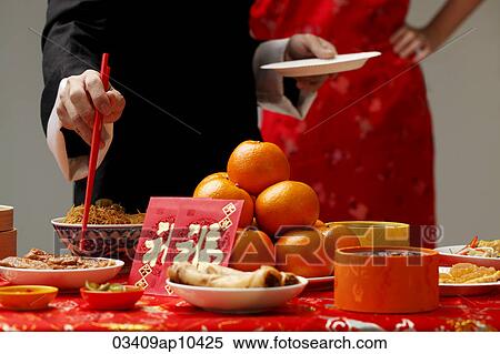 Stock Photography - Crop shot of someone getting food during Chinese New Year party.. Fotosearch