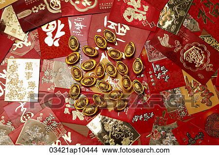 Picture - Gold money, ingot scattered on red packets or Hong Baos. Fotosearch