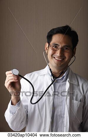 male doctor wearing a stethoscope and smiling View Large Photo Image Picture - male doctor wearing a stethoscope and smiling. Fotosearch