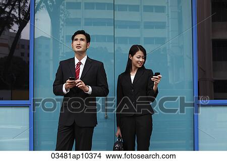 man and woman wearing suites and holding phones View Large Photo Image Picture - man and woman wearing suites and holding phones. Fotosearch
