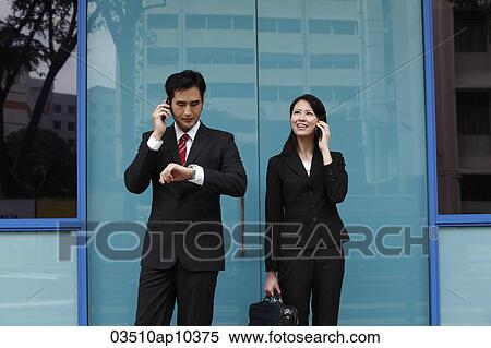 Man and woman wearing suits and talking on phones View Large Photo Image Stock Photography - Man and woman wearing suits and talking on phones. Fotosearch