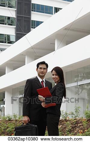 man and woman wearing suits standing in front of building View Large Photo Image Stock Image - man and woman wearing suits standing in front of building. Fotosearch