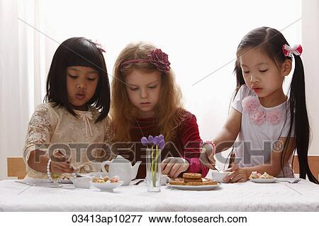 Three young girls having a tea party View Large Photo Image Stock Photo - Three young girls having a tea party. Fotosearch