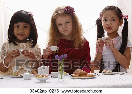 Three young girls having a tea party View Large Photo Image Stock Photograph - Three young girls having a tea party. Fotosearch