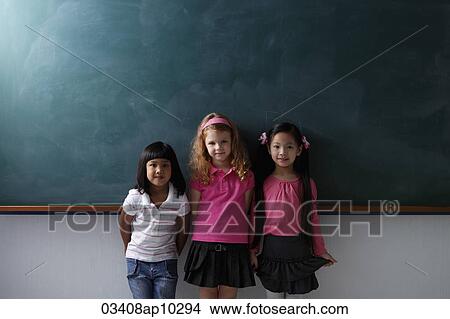 three young girls standing in front of chalk board View Large Photo Image Picture - three young girls standing in front of chalk board. Fotosearch