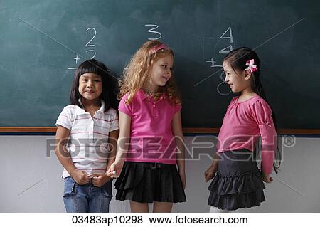 three young girls standing in front of a chalk board, smiling at each other View Large Photo Image Stock Photo - three young girls standing in front of a chalk board, smiling at each other. Fotosearch