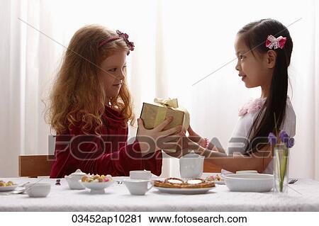 two girls sharing a gift View Large Photo Image Stock Image - two girls sharing a gift. Fotosearch