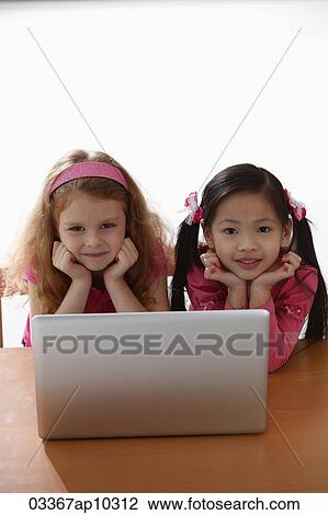 two young girls playing with laptop View Large Photo Image Stock Image - two young girls playing with laptop. Fotosearch