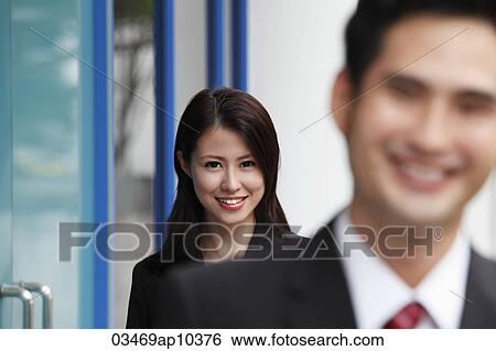 woman smiling with man out of focus in foreground View Large Photo Image Stock Photograph - woman smiling with man out of focus in foreground. Fotosearch