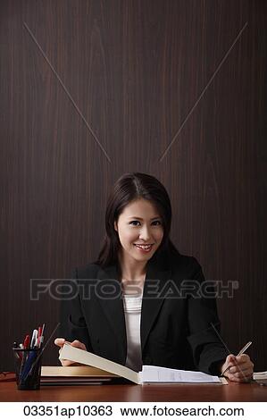 woman working and smiling at her desk View Large Photo Image Stock Image - woman working and smiling at her desk. Fotosearch