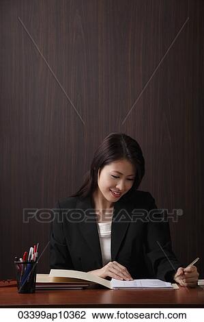 Stock Image - Woman working at her desk. Fotosearch