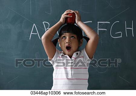 Young girl holding apple on top of her head View Large Photo Image Stock Photograph - Young girl holding apple on top of her head. Fotosearch