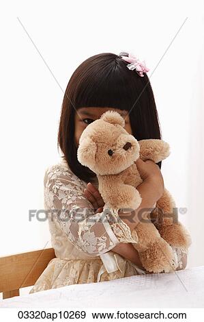 young girl holding teddy bear in front of her face View Large Photo Image Stock Photo - young girl holding teddy bear in front of her face. Fotosearch