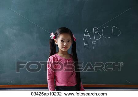 young girl standing in front of chalk board View Large Photo Image Stock Image - young girl standing in front of chalk board. Fotosearch