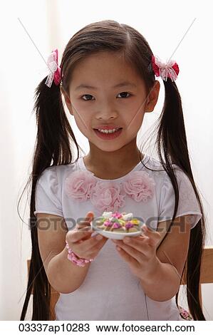 young girl with pony tails holding cookies View Large Photo Image Stock Image - young girl with pony tails holding cookies. Fotosearch