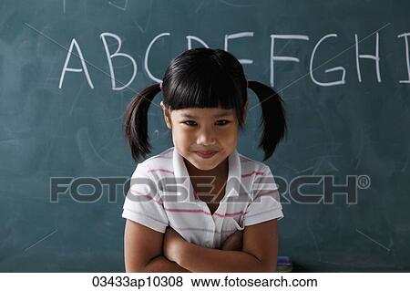young girl with pony tails smiling in front of chalk board View Large Photo Image Stock Photo - young girl with pony tails smiling in front of chalk board. Fotosearch