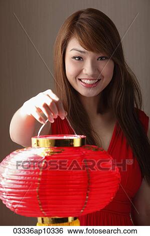 Young woman holding red lantern and smiling View Large Photo Image Stock Photograph - Young woman holding red lantern and smiling. Fotosearch