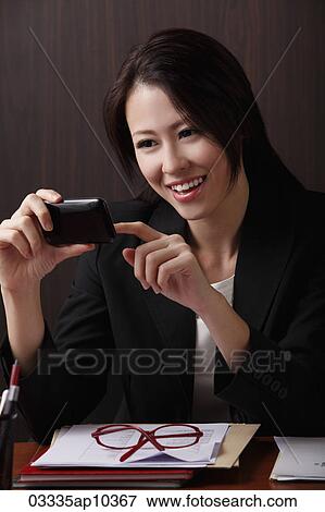 Young woman looking at phone View Large Photo Image Stock Photo - Young woman looking at phone. Fotosearch