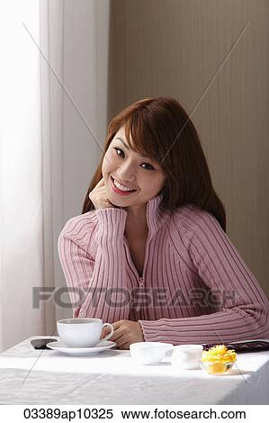 Young woman sitting in cafe near window View Large Photo Image Stock Photography - Young woman sitting in cafe near window. Fotosearch