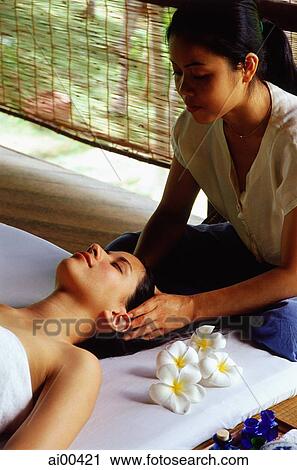 Asian masseuse massaging temples of Eurasian female lying down View Large Photo Image Stock Image - Asian masseuse massaging temples of Eurasian female lying down. Fotosearch