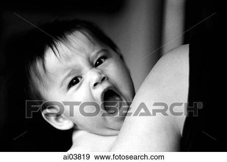 Baby yawning in arms of mother View Large Photo Image Stock Photo - Baby yawning in arms of mother. Fotosearch