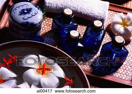 Blue glass bottles beside a bowl with floating fresh flowers View Large Photo Image Stock Photo - Blue glass bottles beside a bowl with floating fresh flowers. Fotosearch