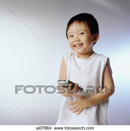 Boy, 3 years old holding remote control, smiling. View Large Photo Image Picture - Boy, 3 years old holding remote control, smiling.. Fotosearch