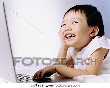 Boy, 3 years old, using laptop, smiling. View Large Photo Image Stock Photo - Boy, 3 years old, using laptop, smiling.. Fotosearch