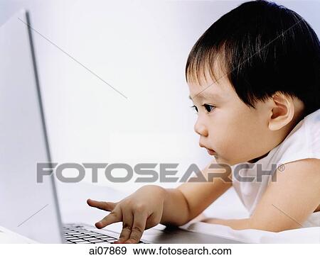 Stock Photo - Boy, 3 years old, using laptop.. Fotosearch