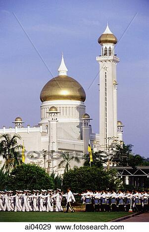 Stock Photo - Brunei, Air force airmen march during Sultan Hassanal Bolkiah's birthday celebrations, Omar Ali Saifuddien mosque in background.. Fotosearch