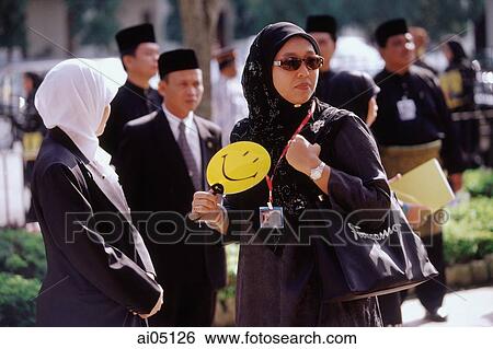 Stock Photograph - Brunei Darussalam, Borneo, A Muslim woman fanning herself to keep cool.. Fotosearch