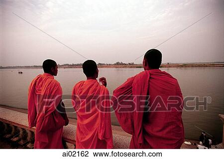 Cambodia, Phnom Penh, Buddhist monks watching the muddy, slow-moving Mekong River along a riverfront promenade. View Large Photo Image Stock Image - Cambodia, Phnom Penh, Buddhist monks watching the muddy, slow-moving Mekong River along a riverfront promenade.. Fotosearch