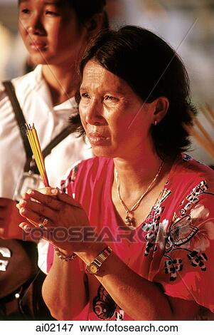 Cambodia, Phnom Penh, Worshippers pray with incense at a temple. View Large Photo Image Stock Photo - Cambodia, Phnom Penh, Worshippers pray with incense at a temple.. Fotosearch