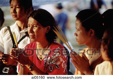 Cambodia, Phnom Penh, Worshippers praying with incense at a temple. View Large Photo Image Stock Image - Cambodia, Phnom Penh, Worshippers praying with incense at a temple.. Fotosearch