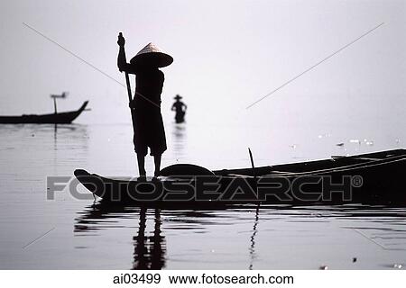 Stock Photo - Cambodia, Ton Le Sap River, A fisherman poles along the water. Fotosearch