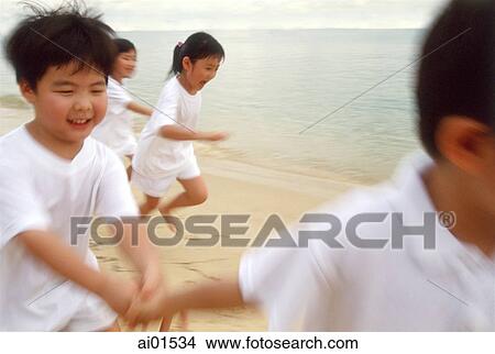 Children in white outfits running along the beach View Large Photo Image Picture - Children in white outfits running along the beach. Fotosearch