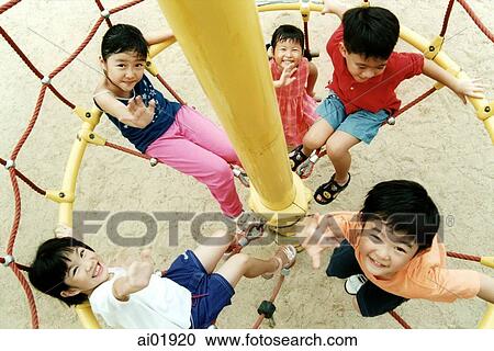 Stock Image - Children waving inside a jungle gym. Fotosearch