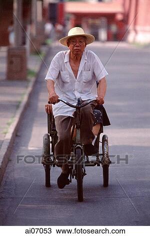 China, Beijing, man cycling, hat on head View Large Photo Image Stock Image - China, Beijing, man cycling, hat on head. Fotosearch