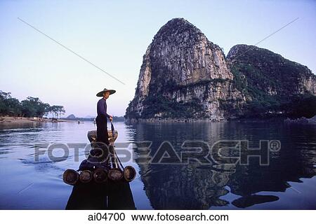 Stock Image - China, Guilin, Fisherman on water, rocks in background.. Fotosearch