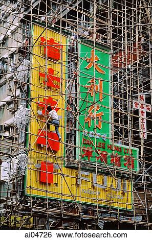Stock Photograph - China, Hong Kong, man on scaffolding working on signs. Fotosearch