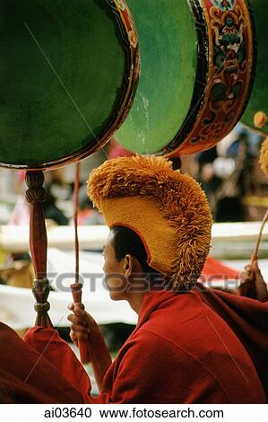 Stock Image - China, Szechuan (Sichuan), Kham region, Monk playing drums at Temple Puja.. Fotosearch
