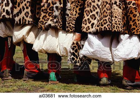 Stock Image - China, Szechuan (Sichuan), Kham region, Khampa men stand, wearing their traditional costumes of long, fur-trimmed jackets.. Fotosearch