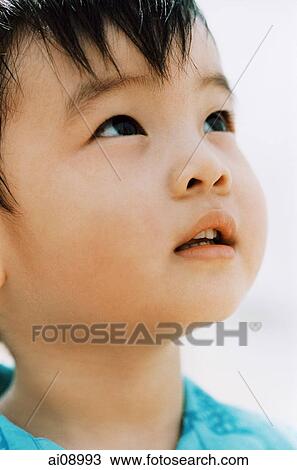 Stock Image - Close-up of young boy looking up. Fotosearch