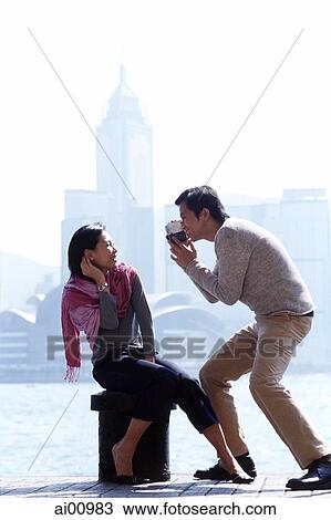 Couple by waterfront, man holding video camera View Large Photo Image Stock Image - Couple by waterfront, man holding video camera. Fotosearch