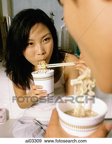 Couple eating instant noodles View Large Photo Image Stock Photo - Couple eating instant noodles. Fotosearch