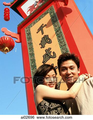 Couple embracing in front of chinese sign, lantern and blue sky in background. View Large Photo Image Stock Photograph - Couple embracing in front of chinese sign, lantern and blue sky in background.. Fotosearch